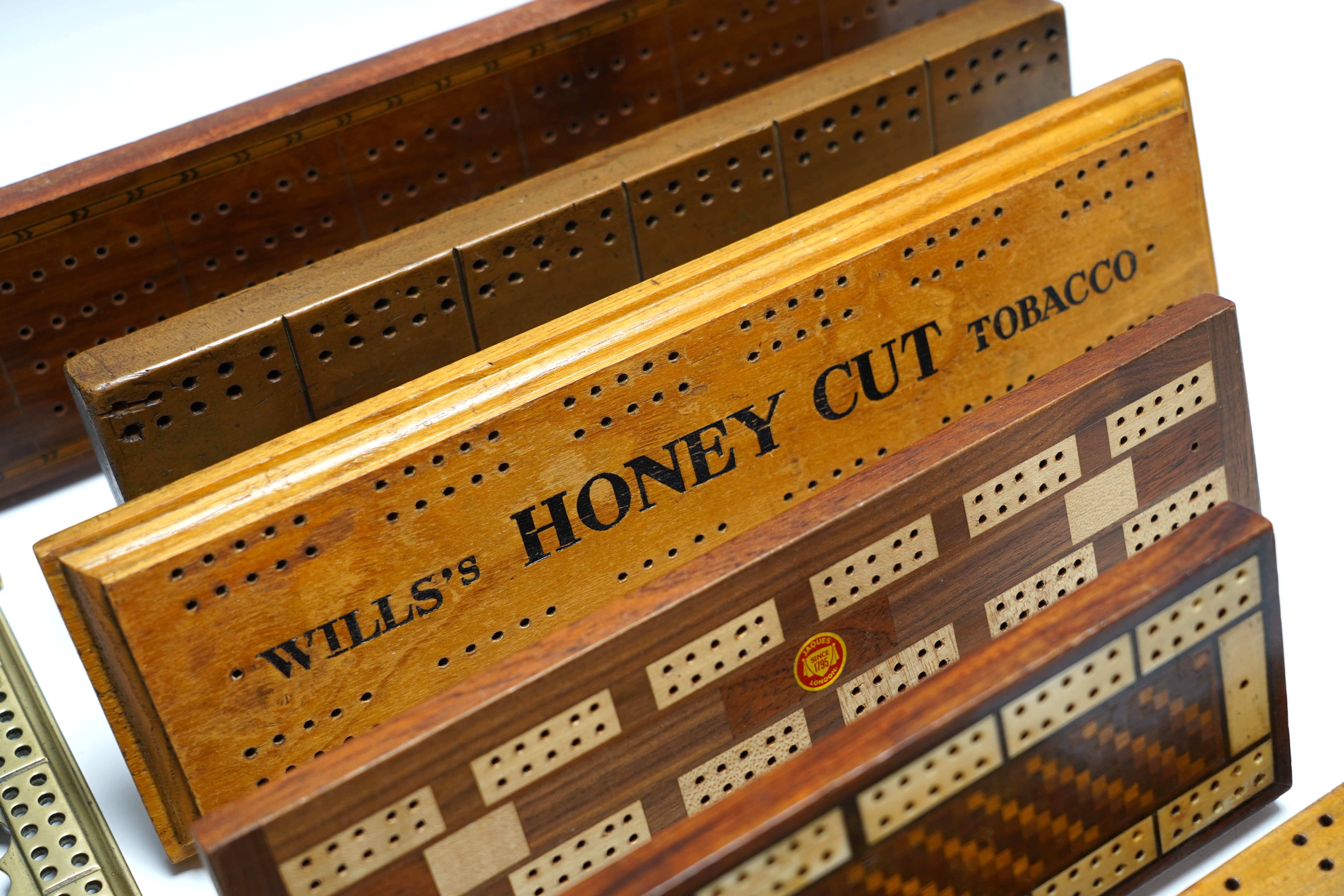 Nine cribbage boards including a horn example, 'Wills Tobacco' advertising and bone and marquetry examples, largest 42cm in length